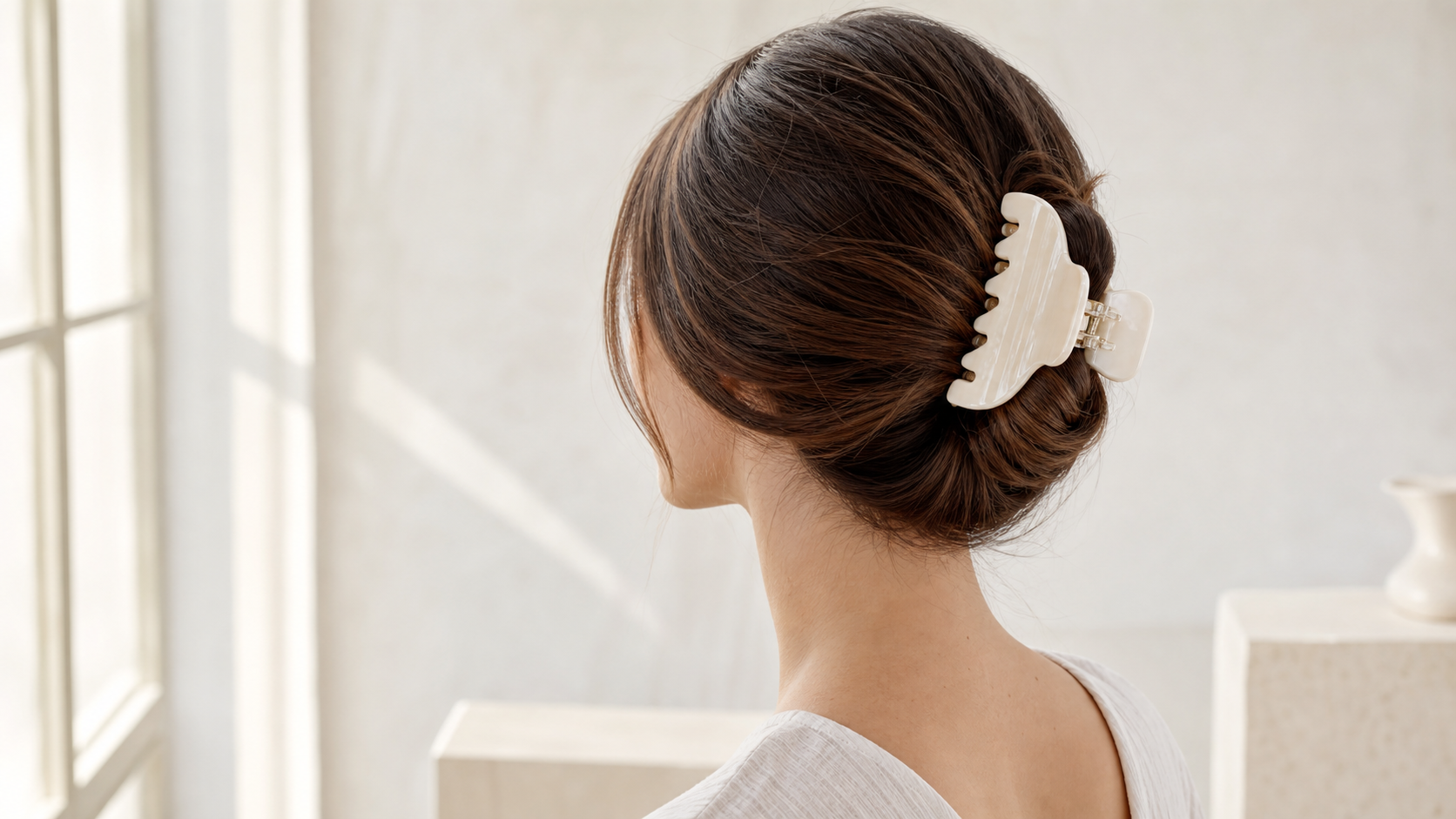 Woman wearing an ivory acetate claw clip in a soft low bun