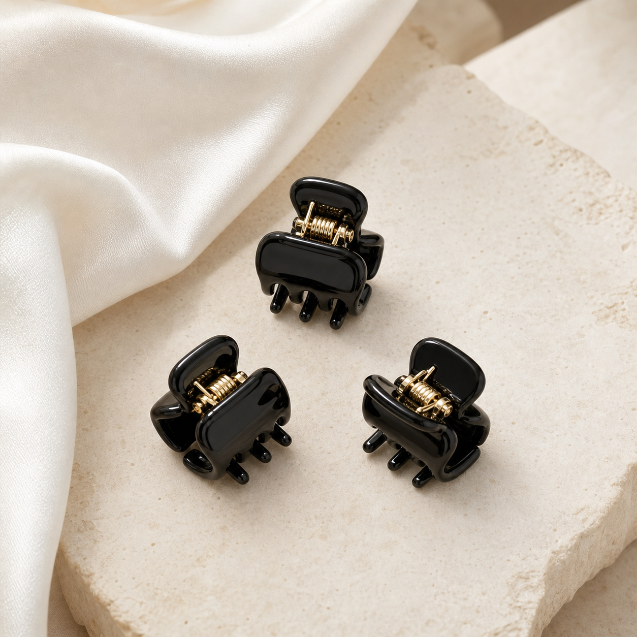 Black glossy mini acetate hair clips on ivory stone