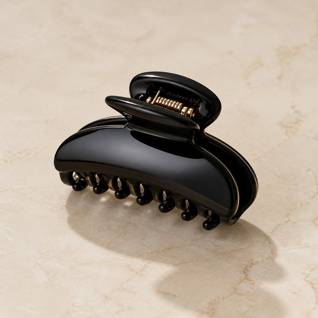 Glossy black acetate hair claw clip on ivory marble